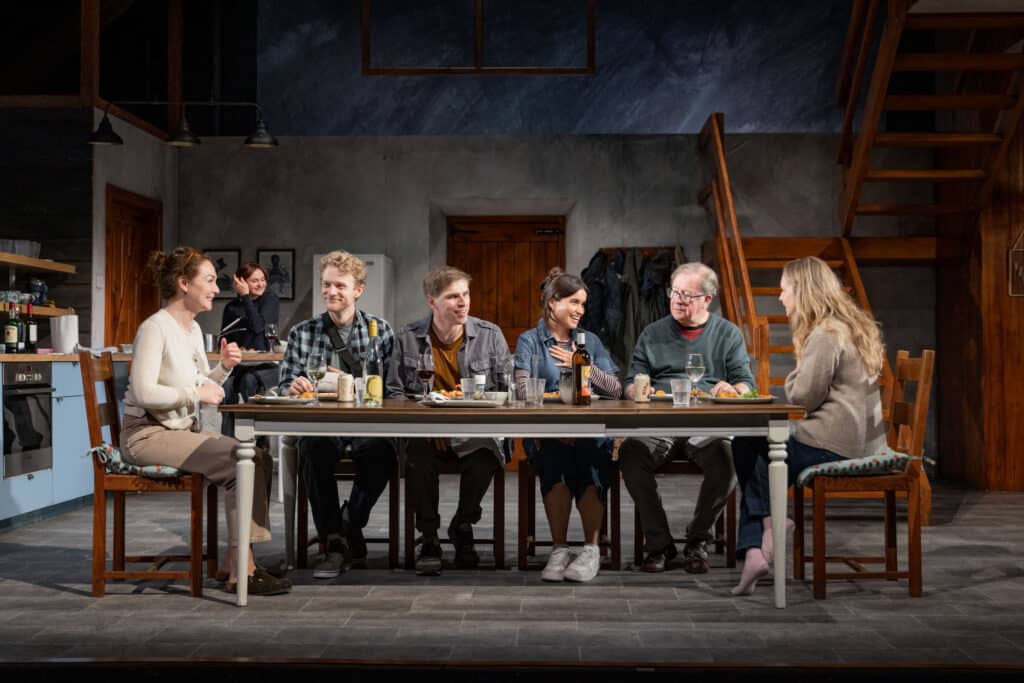 The cast of 'Reunion' on stage, around the dinner table.